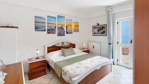 Un dormitorio con cama, mesitas de noche, una ventana con cortinas y decoración en la pared.