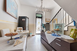 A hotel room with a dining area, a minibar, a staircase, and a world map on the wall.