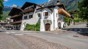 A traditional Alpine building with a wooden balcony, a sign reading 'Hotel 1922,' and a cobblestone street.