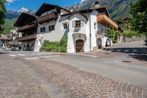 A traditional Alpine building with a wooden balcony, a sign reading 'Hotel 1922,' and a cobblestone street.