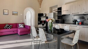 Una cocina moderna con comedor, sofá y obras de arte en las paredes.