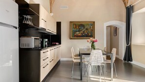 Una cocina moderna con comedor, que incluye un microondas, armarios y un cuadro en la pared.