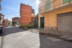 Een straat met gebouwen, een dicht garageportaal en een parkeerverbodsbord.