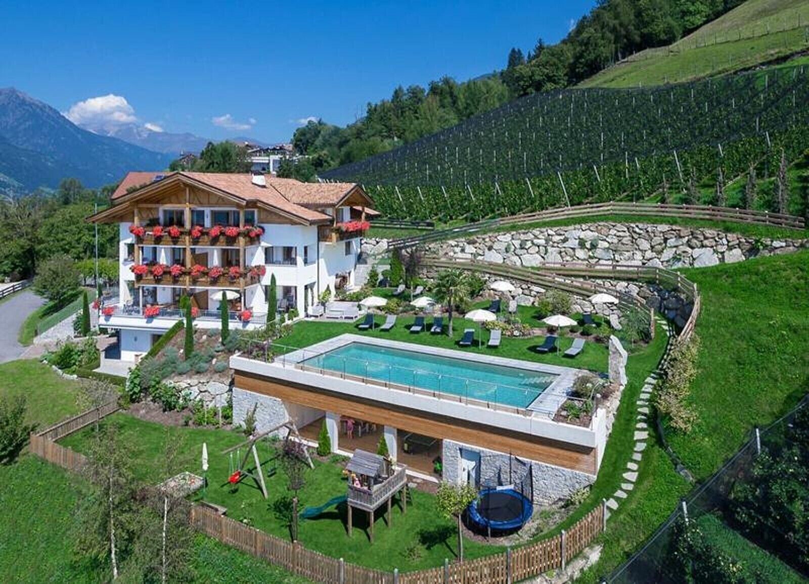 Un bâtiment à deux étages doté d’une piscine, d’un espace extérieur aménagé et offrant une vue sur le paysage environnant.
