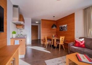Un salon moderne comprenant un canapé, une table basse et un coin repas avec une table et des chaises.