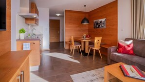 Un salon moderne comprenant un canapé, une table basse et un coin repas avec une table et des chaises.