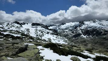 A mountainous landscape with snow-covered peaks and rocky terrain.
