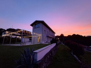 Een tweelaags huis met een balkon en lichtslingers.