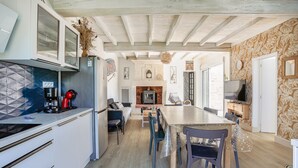 Eine moderne Küche mit Essbereich, Kamin und Fernseher.