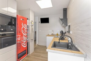 Una cocina moderna equipada con microondas, horno, refrigerador y pileta.