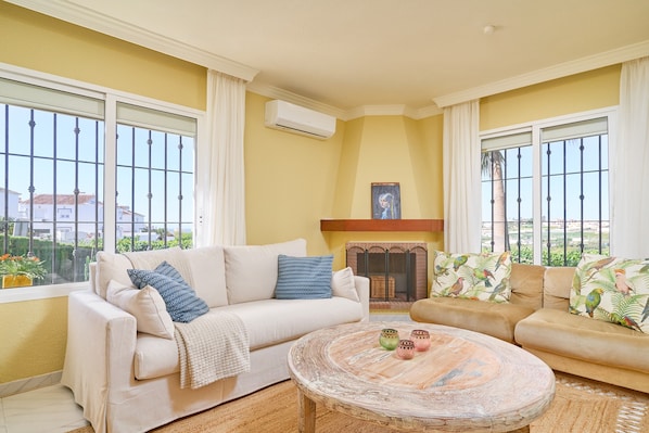 A living room with a sofa, a coffee table, and a fireplace.