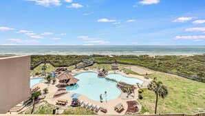 A resort with a large pool, lounge chairs, and a view of the ocean. - Oceanfront Penthouse | 3BR/2BA | Pools, Beach Access & Incredible Views (Port Aransas)