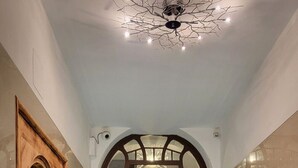 Ein Korridor mit einer Holztür, einem Chandelier und einem Schild mit der Aufschrift 'Nekazanka 8'.