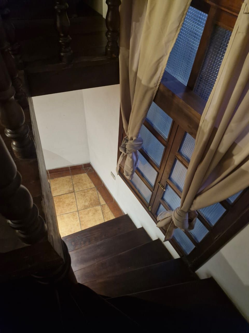Una escalera que lleva a una habitación con una ventana y una puerta.