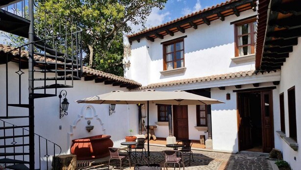 A courtyard with a patio area, outdoor seating, and a staircase. - Cozy Colonial Style Azotea Apartments (Jocotenango)