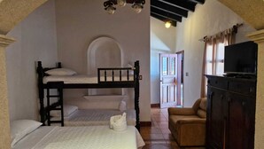 A room with bunk beds, a television, and a sofa. - Cozy Colonial Style Azotea Apartments (Jocotenango)