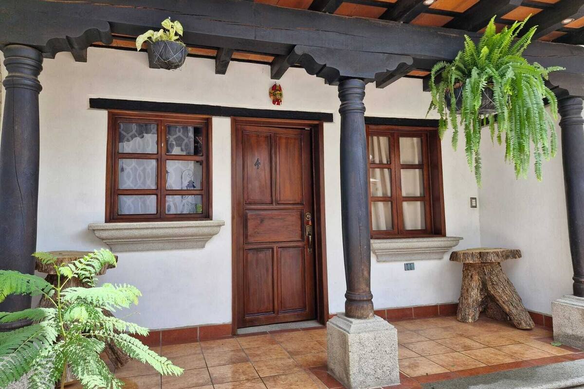 A traditional building with a wooden door, two windows, and a hanging plant.