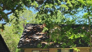 A single-story house with a dark roof, beige siding, and a front door. There is a small front yard with a pathway leading to the door. - Charming 2-bedroom home with fenced yard sleeps 6 in Baton Rouge near Tigerland (Baton Rouge)
