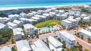 A resort with multiple-story buildings, a central pool, and a beach view.