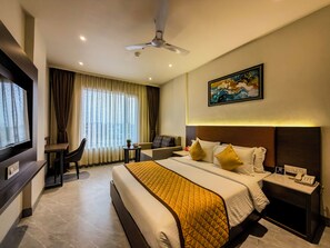 A hotel room with a bed, a desk, a chair, a TV, a ceiling fan, and a painting on the wall. - ZiP By Spree Hotels Pandharpur (Pandharpur)