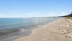 A beach with a clear sky and calm sea. - Toogoom Beach Vibes. Absolute Beachfront Home with pool! 4BR (Toogoom)