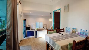 A room with a dining table, chairs, a kitchen area, and a view of the outdoors. - Dream Villa Beachfront Sunset (Koh Samui)