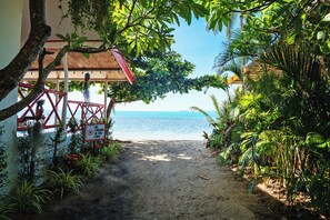 A pathway leading to a beach with a no parking sign, surrounded by lush greenery and a clear view of the sea. - Dream Villa Beachfront Sunset (Koh Samui)