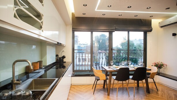 A modern kitchen with a dining area, large windows, and a view of the city. - Apartment in the center of old Hanoi! (Hà Nội)