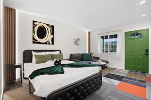 Ein modernes Schlafzimmer mit einem großen Bett, einer Couch und einer grünen Tür.