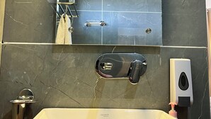A bathroom with a large mirror, a modern sink, and a soap dispenser. - LADAKH COUNTRY INN (Leh)