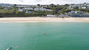 Une ville côtière dotée d’une plage de sable et de maisons construites sur une colline.