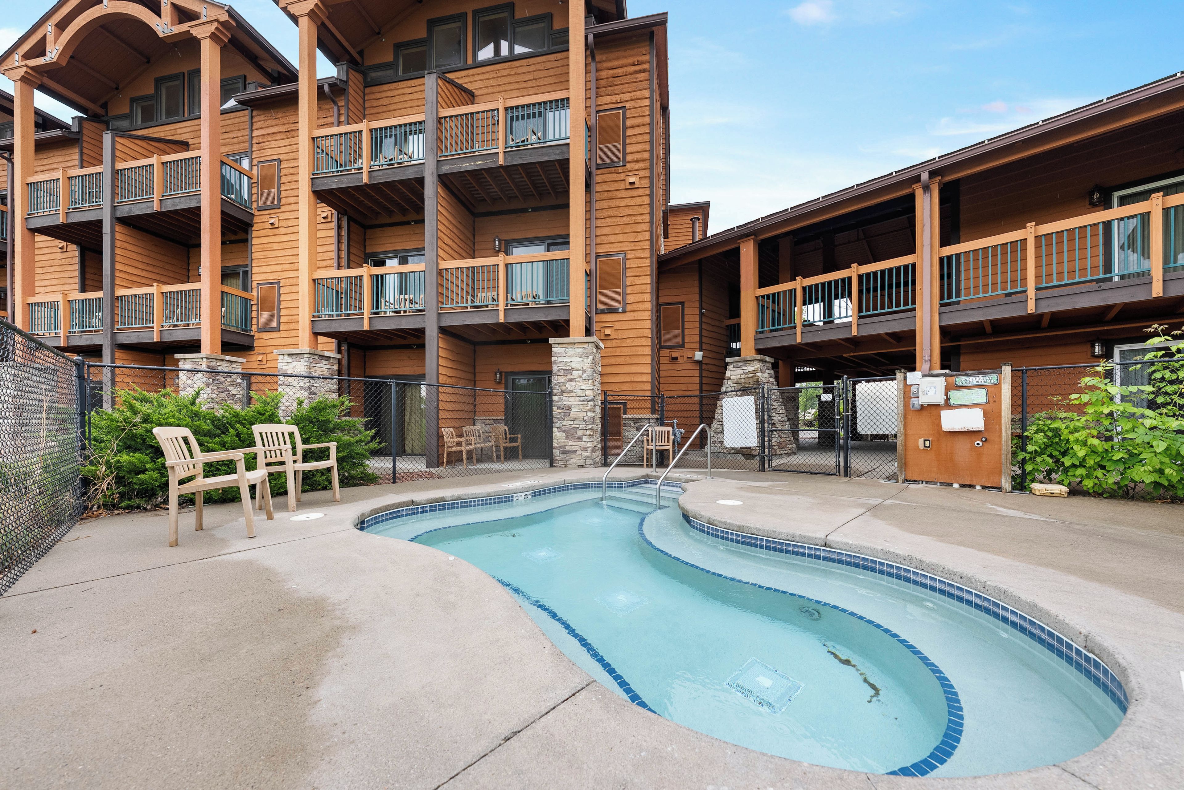 Un immeuble à plusieurs étages doté de balcons, d’une piscine et d’un espace extérieur aménagé pour s’asseoir.