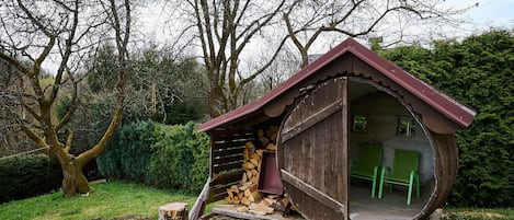 Une construction rustique en bois, dotée d’un toit en pente, d’une porte et d’une petite fenêtre.