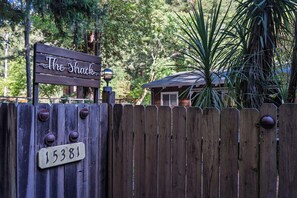 A wooden gate with a sign reading 'The Shack' and a house number sign. - Hot Tub Retreat Near Russian River • BBQ • Family Friendly (Guerneville)