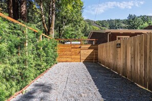 A gravel driveway leading to a wooden gate with a guest parking sign. - Hot Tub Retreat Near Russian River • BBQ • Family Friendly (Guerneville)