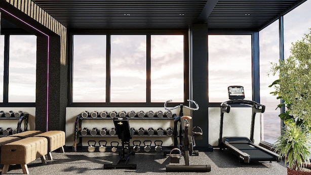 A modern gym with exercise equipment, large windows, and a view of the sky. - The Signature Hotel Saigon (Ho Chi Minh City)
