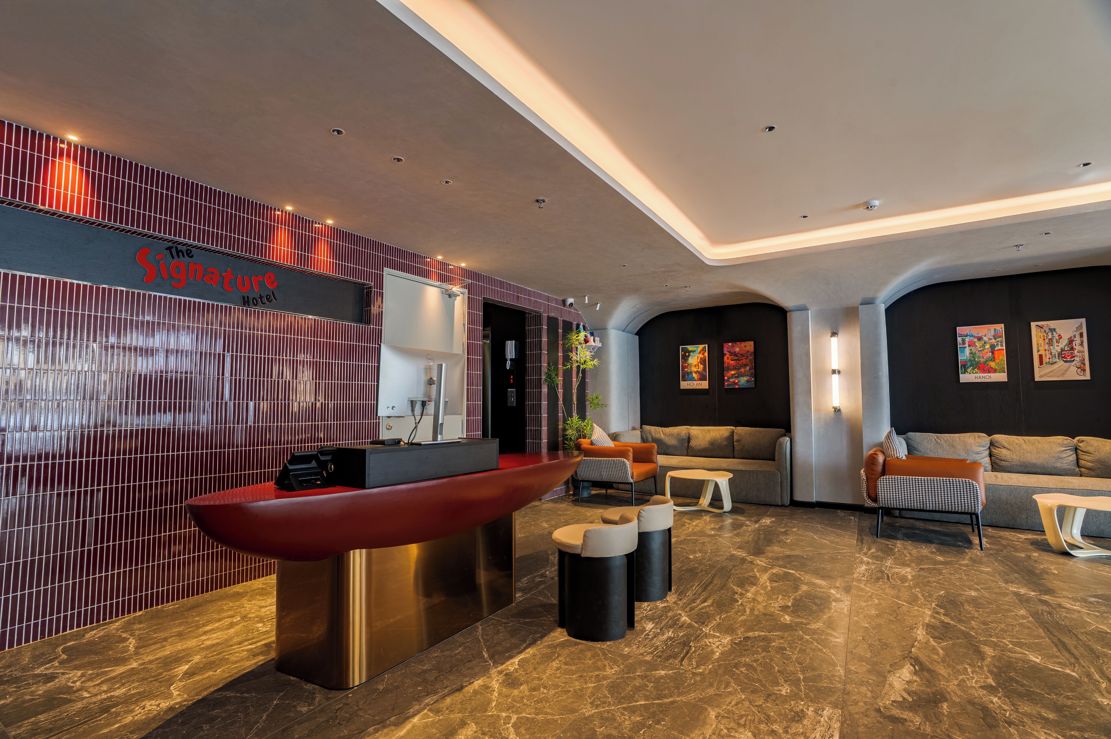 A modern hotel lobby with a reception desk, seating area, and artwork on the walls.