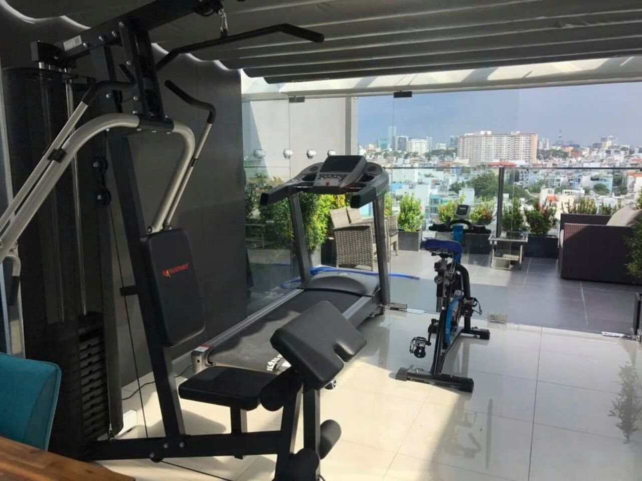 A home gym with a treadmill, weight bench, and exercise bike.