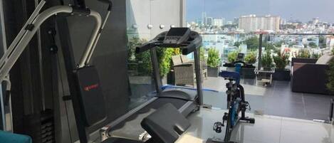 A home gym with a treadmill, weight bench, and exercise bike.