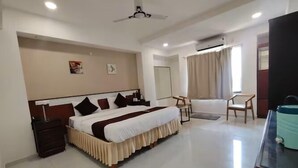 A hotel room with a large bed, a desk, a chair, and a bathroom. - Shubh Shaleen Springs by Nexottel (Bhopal)