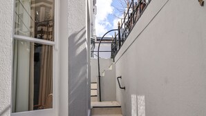 Una escalera estrecha que lleva a una plataforma con barandilla de metal.