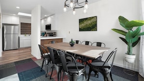 A modern kitchen with white cabinets, a stainless steel refrigerator, and a wooden countertop. - 4Beds Private Unit Near BeachWalk Golf (Pacifica)