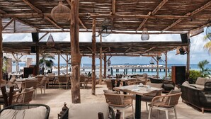 An outdoor seating area with wicker furniture and a view of the ocean.