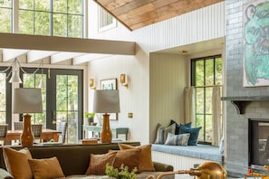 A spacious living room with a high ceiling, large windows, a fireplace, and a cozy seating area. - The Carly Fern Lodge | Luxe Wine Country Experience, Entire Lake, Trails & 21 Gorgeous Acres (Carlton)