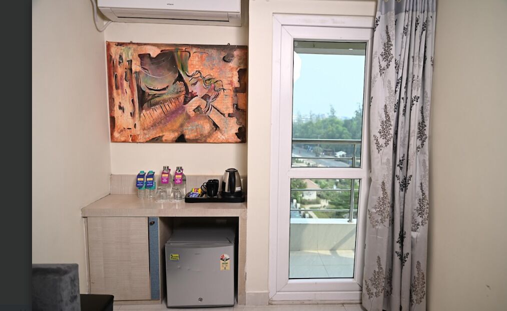 A kitchenette with a refrigerator, a coffee maker, and bottled water.
