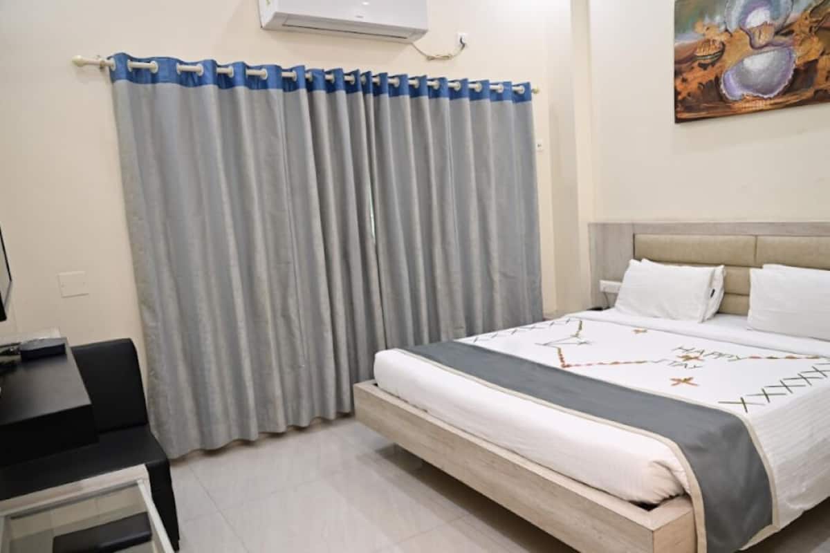Un dormitorio con una cama, un escritorio y una silla.