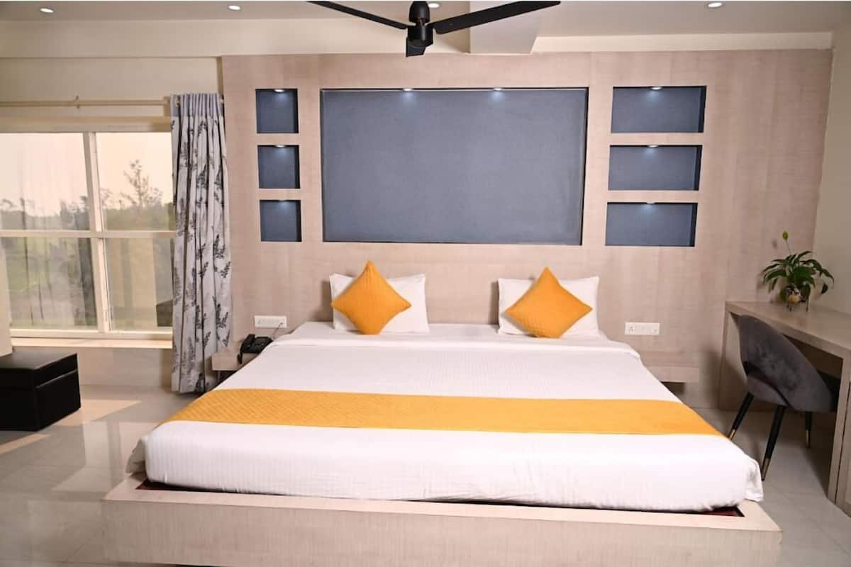 Una habitación de hotel moderna con una cama grande, un escritorio y un ventilador de techo.