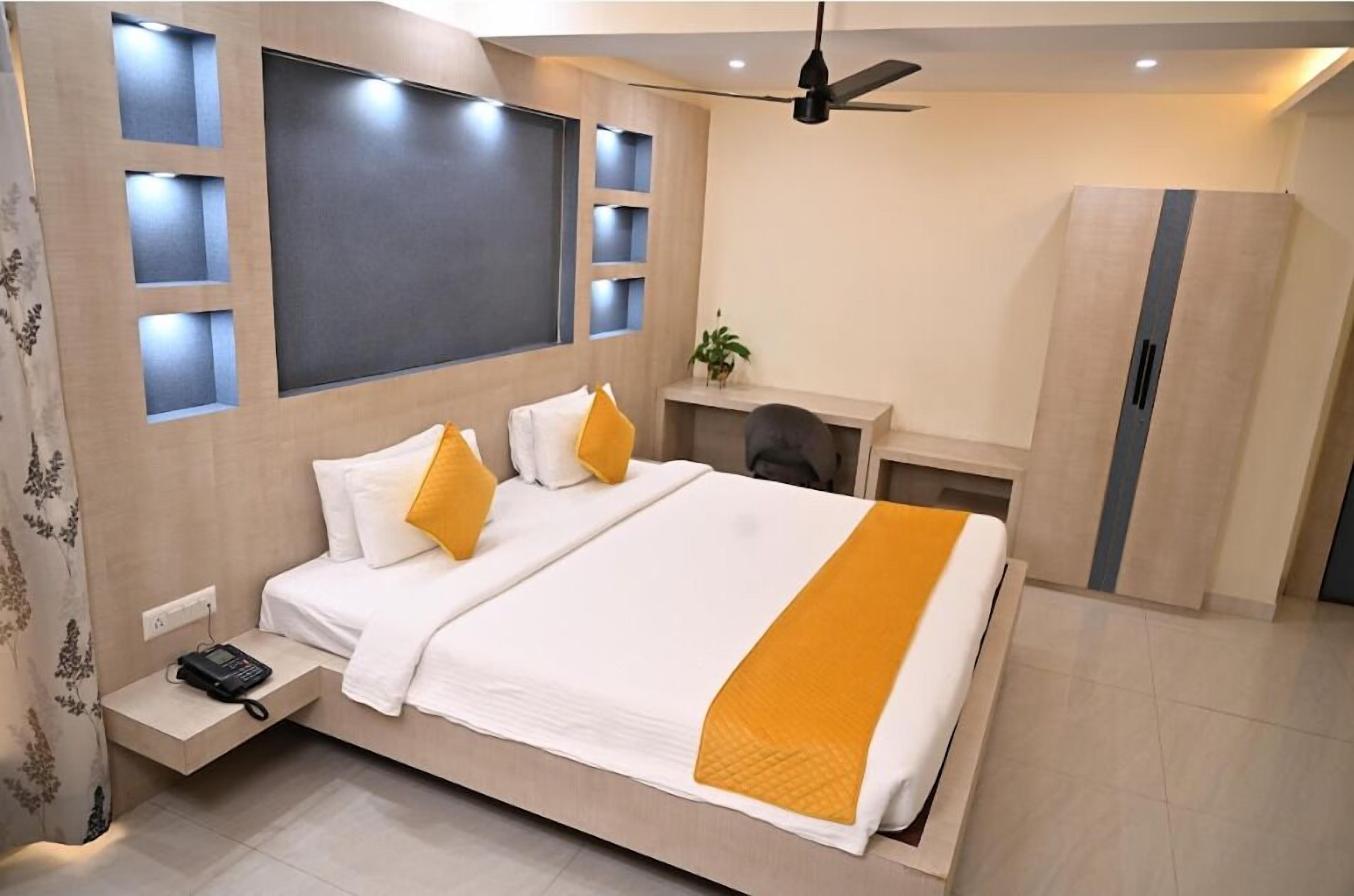 A modern bedroom with a large bed, bedside table, and a built-in TV.