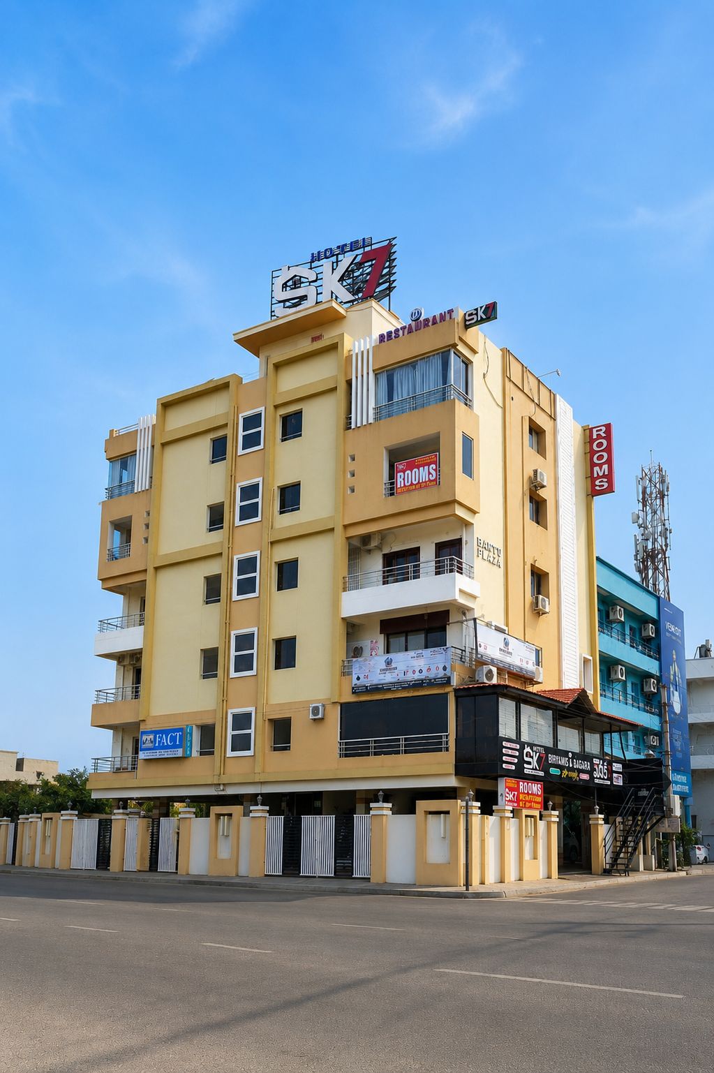 Un hotel de varios pisos con un cartel llamativo que anuncia habitaciones y un restaurante en el piso superior.