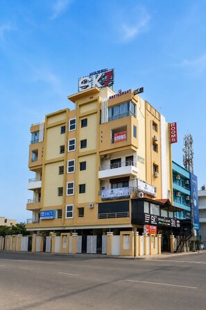 A multi-story hotel with a prominent sign for rooms and a restaurant on the upper floor. - Hotel SK7 SERVICE APARTMENTS  (Vijayawada)